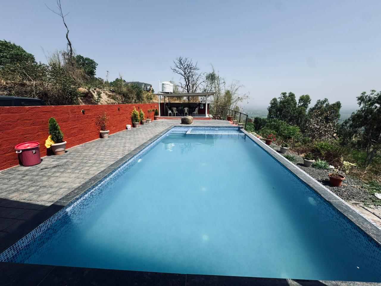 Infinity swimming pool at V-Farms with panoramic greenery and open sky