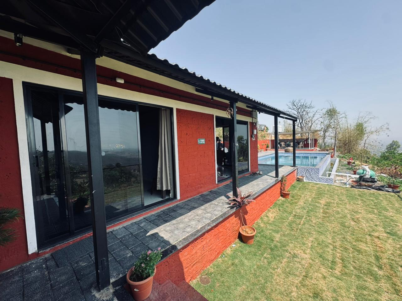Side view of the V-Farms villa with lawn, veranda and pool deck